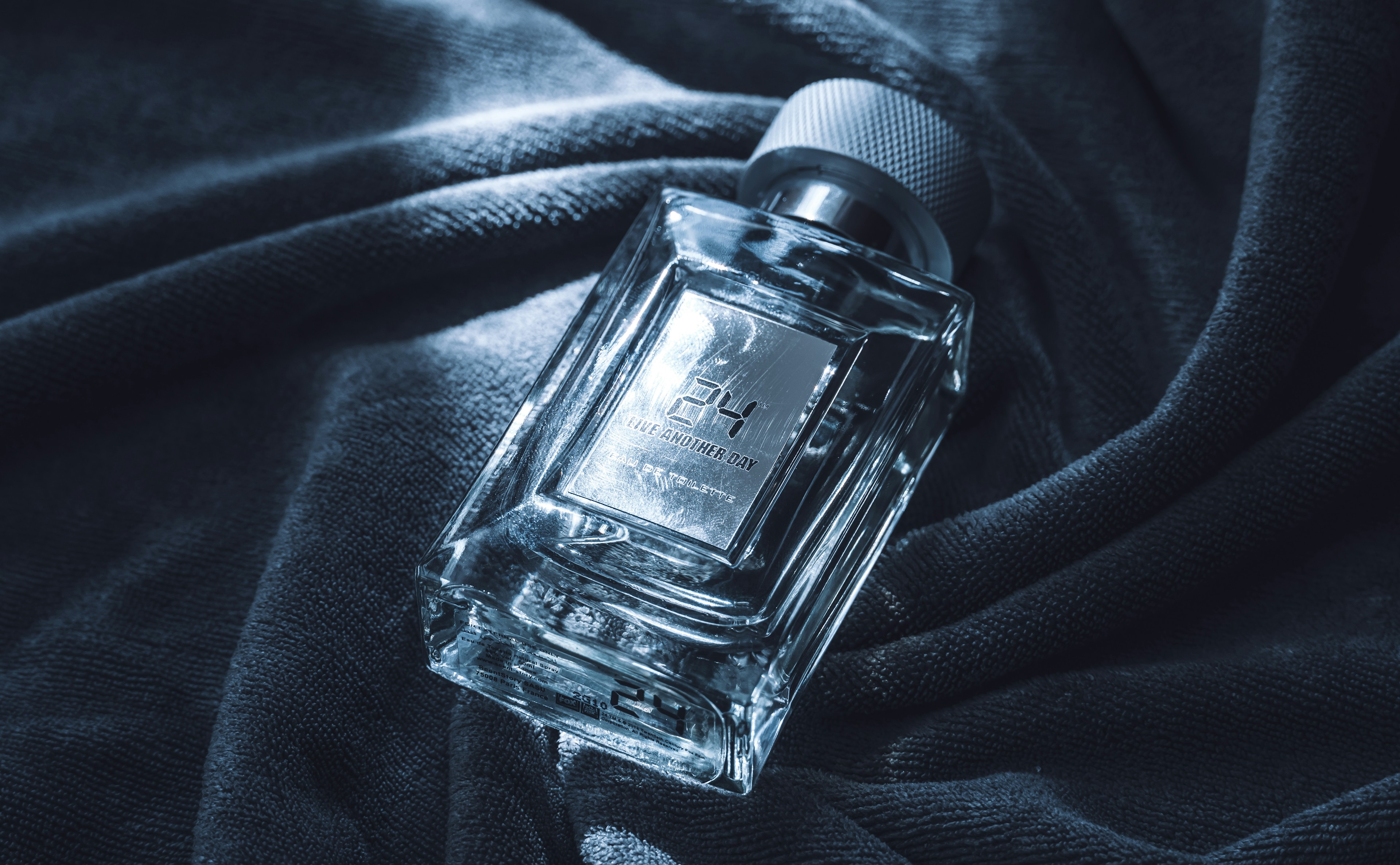 زجاجة عطر رجالي على قماش أزرق داكن